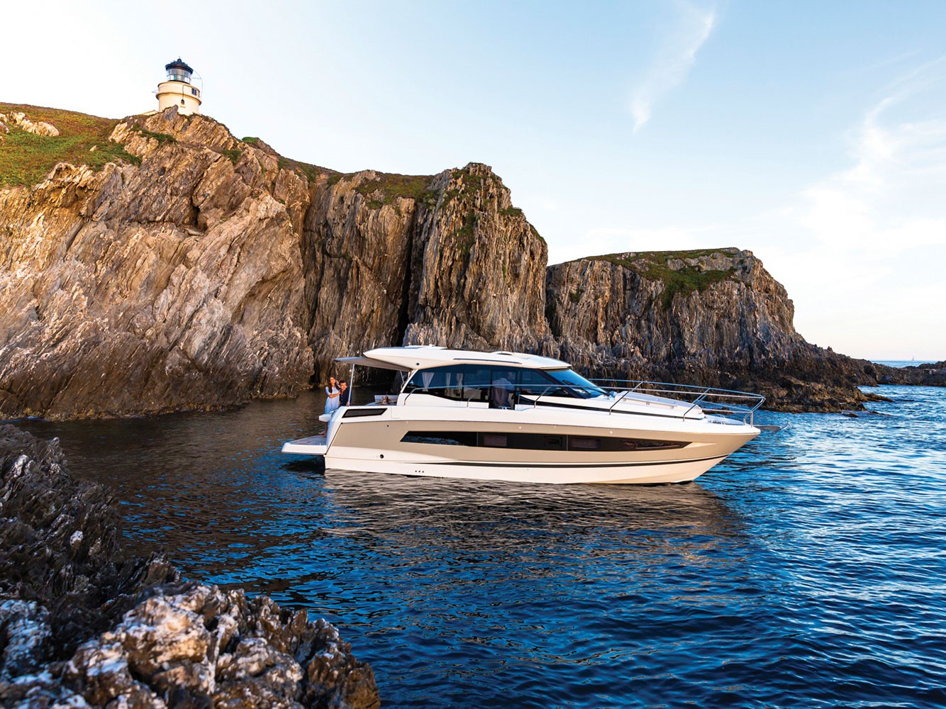 Jeanneau NC 37 in a secluded bay surrounded by rocky cliffs 