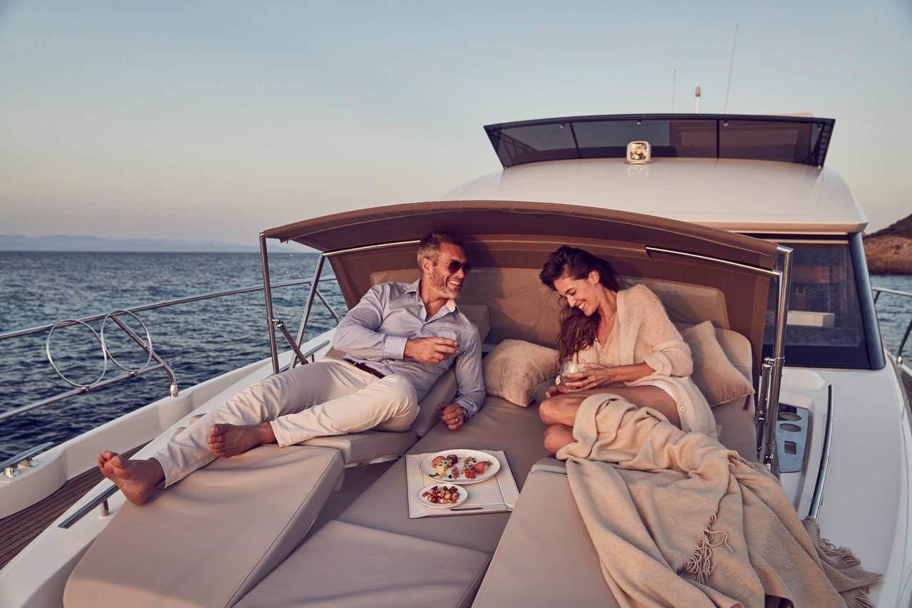 Couple enjoying the foredeck lounge area on the Prestige Yachts 520, at sunset