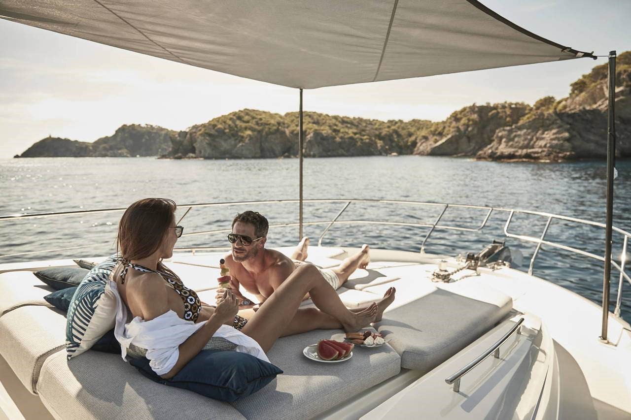 Couple enjoying the foredeck lounge on the Prestige Yachts 590