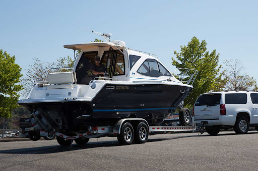 Blue 24' Cutwater on trailer behind white SUV